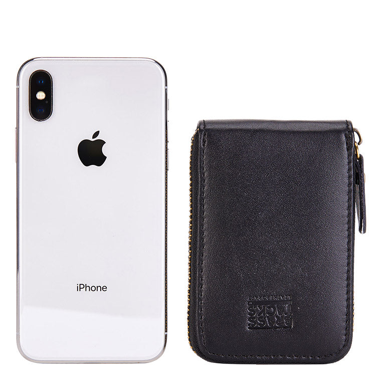 Black Mercer leather card wallet shown beside a smartphone for scale