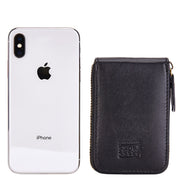 Black Mercer leather card wallet shown beside a smartphone for scale