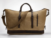 A tan canvas duffel bag with dark brown leather handles, straps, and trim, shown on a light gray background.