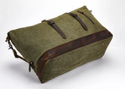 An olive green canvas duffel bag with dark brown leather trim and straps, shown on a clean white background.
