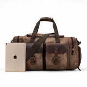 Dark Brown | Dark brown waxed canvas duffel shown beside a tablet for scale