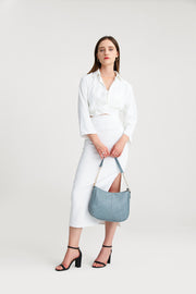 Blue | Woman carrying the Harper blue hobo bag by the chain strap