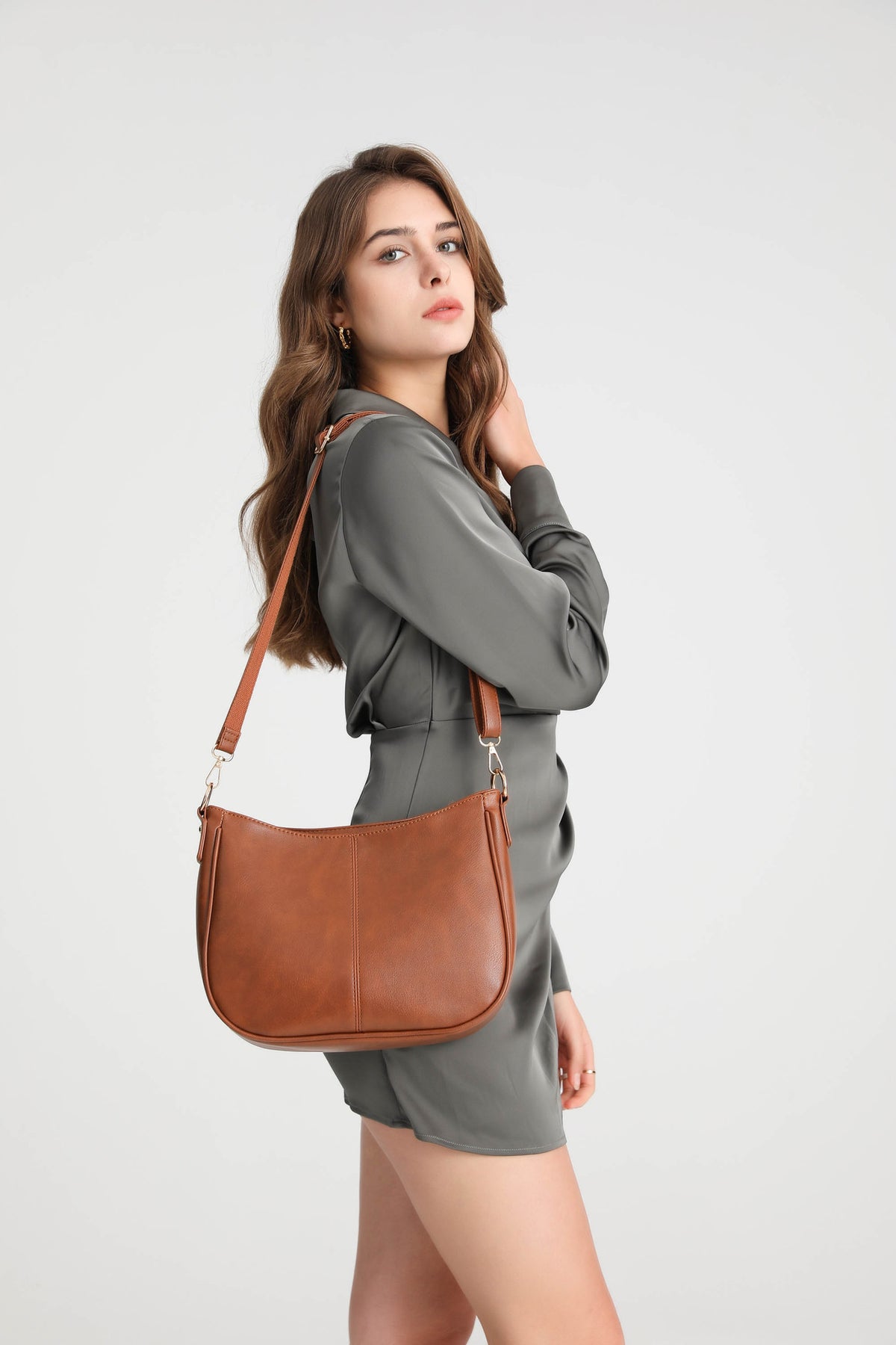 Brown | Woman carrying the Harper brown hobo bag with adjustable crossbody strap
